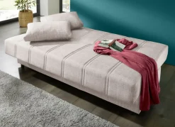 Frei im Raum aufstellbares Schlafsofa mit Dekokissen und Bettkasten