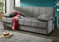Frei im Raum aufstellbares Schlafsofa mit Dekokissen und Bettkasten